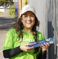  mulher branca com cabelo preto e blusa verde sorrindo para camera 